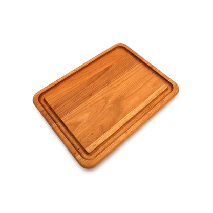 A rectangular wooden cutting board with a natural wood grain finish and raised rim, shown at an angle on a plain white background.