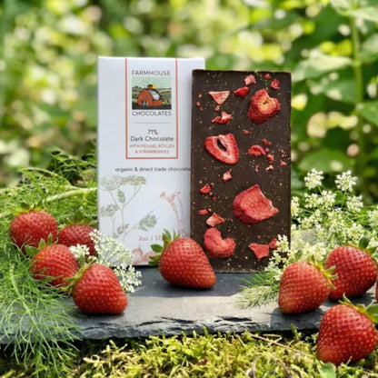 Chocolate bar on slate serving board with fresh strawberries