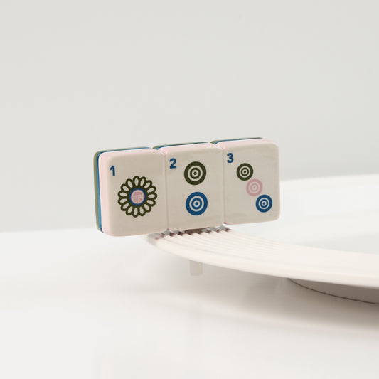 Set of four ceramic tiles with floral and geometric designs on a white background