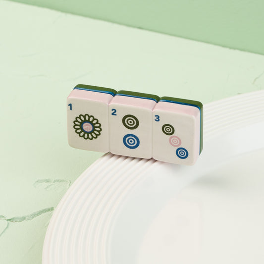 Set of colorful dice with floral and circular designs on a white surface with a green background