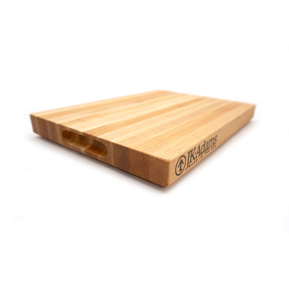 Wooden cutting board with 'IK Adams' branding on a white background