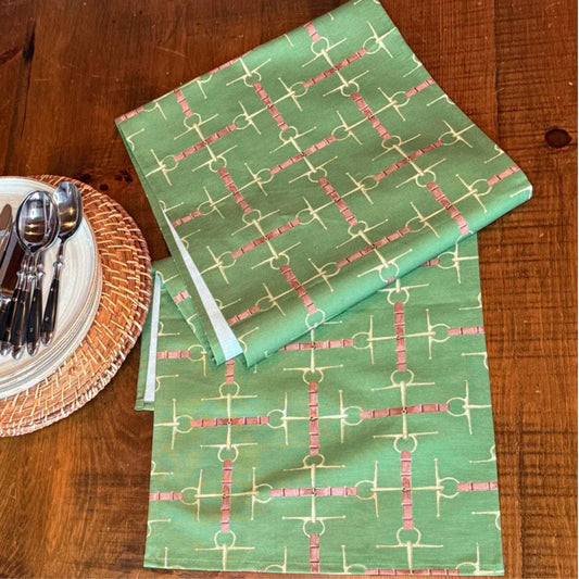 Olive green runner with equestrian bit design on a wooden table. 