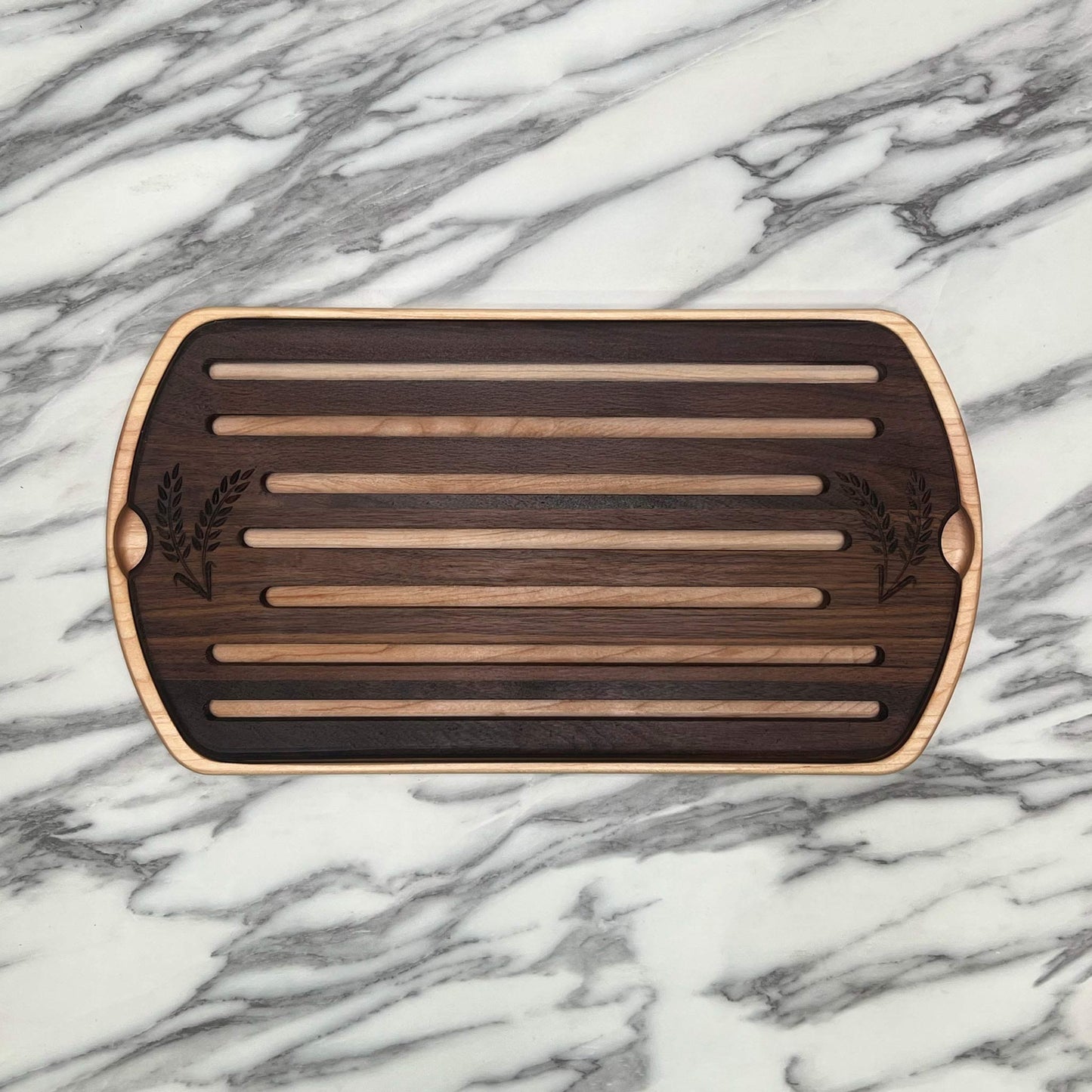 Wooden cutting board with slotted design on a marble surface