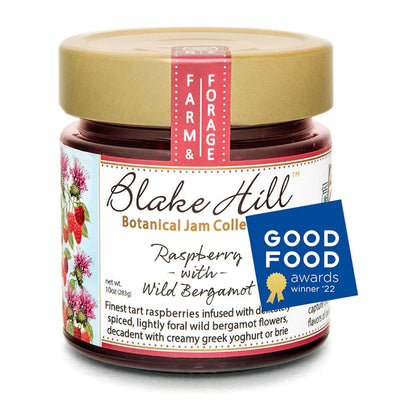Jar of Blake Hill Botanical Jam Collection labeled Raspberry with Wild Bergamot. The jar features berry illustrations. A Good Food Awards winner 22 badge is displayed on the side.