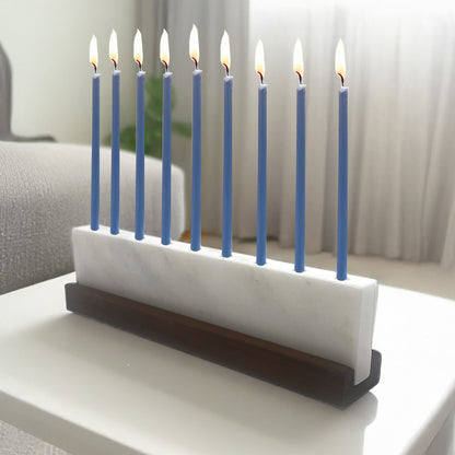 Menorah with blue candles on a white surface