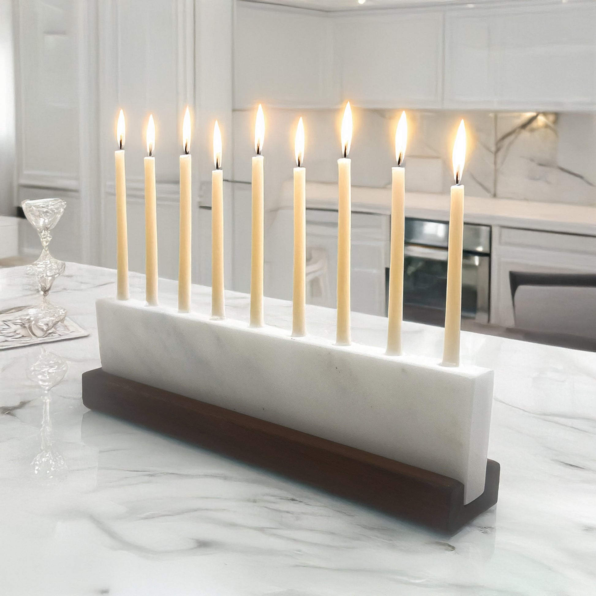 Candle holder with lit candles on a marble surface in a kitchen setting